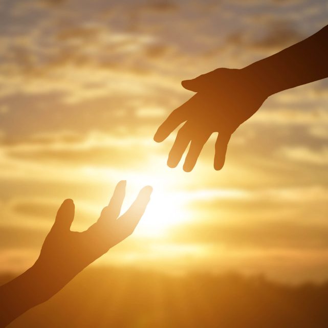 A helping hand silhouette in front of sun