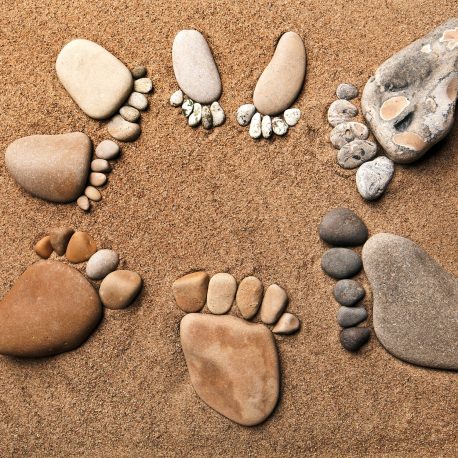 Stones in the shape of footprints on sand